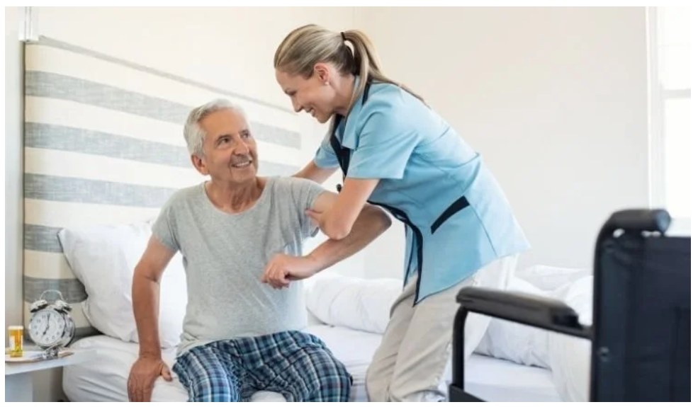 A caregiver helping a client get up safely at home